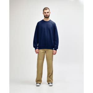 A navy blue Gildan Softstyle adult sweatshirt, shown on a model paired with black pants and sneakers.