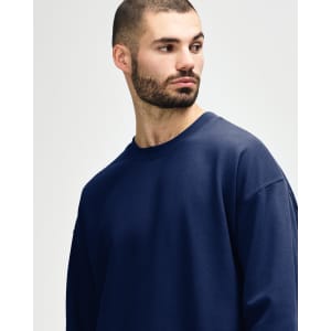 A navy Gildan Softstyle adult sweatshirt featuring a crew neck and long sleeves, with a logo on the sleeve.