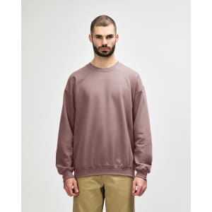 A plain, long-sleeved sweatshirt in a muted mauve colour, featuring a crew neck and relaxed fit. It has a logo.