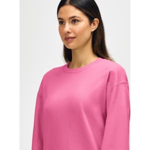 A pink Gildan Softstyle adult sweatshirt featuring a crew neck and long sleeves, with a logo on the front.