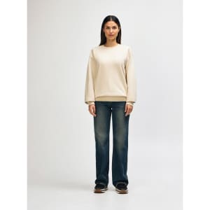 A cream-coloured Gildan Softstyle adult sweatshirt displayed on a model, paired with dark jeans and sneakers.
