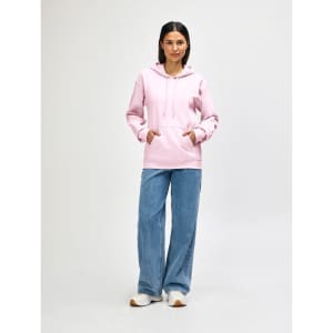 A pink Gildan Softstyle adult hooded sweatshirt worn by a model with blue jeans and white shoes, featuring a logo.