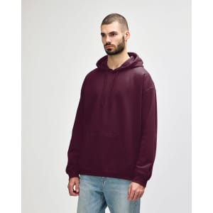 A burgundy adult hooded sweatshirt, featuring a front pocket and a drawstring hood. The model stands casually.