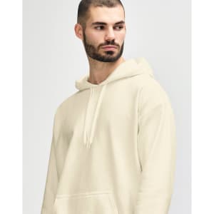 A man wearing a cream-coloured Gildan Softstyle adult hooded sweatshirt, styled with denim jeans and a relaxed pose.