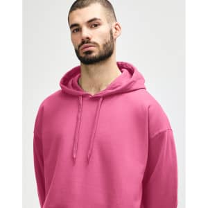 A pink hooded sweatshirt with a drawstring, featuring a hood and a simplistic design, is displayed on a model.