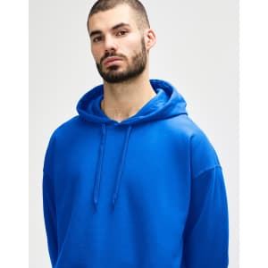 A blue Gildan Softstyle adult hooded sweatshirt worn by a model adjusting the hood. The sweatshirt has a logo.