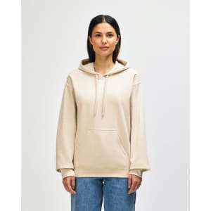 A beige hooded sweatshirt with a front pocket and adjustable drawstrings, worn by a model standing against a plain background.