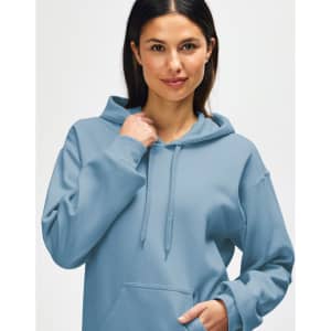 A hooded sweatshirt in a soft blue shade, featuring a drawstring and a relaxed fit, worn by a model.