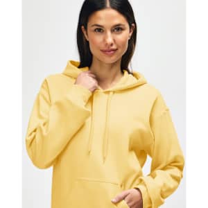 A yellow Gildan Softstyle adult hooded sweatshirt with a kangaroo pocket and a hood. The model has a relaxed expression.