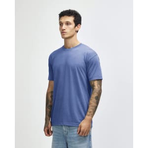 A blue tri-blend T-shirt displayed on a male model with tattoos, featuring a round neckline and short sleeves.