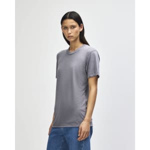 A grey American Apparel tri-blend T-shirt is displayed on a model, featuring a relaxed fit and short sleeves.