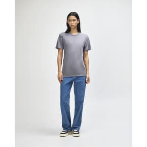 A model stands in a grey American Apparel tri-blend T-shirt and blue jeans, featuring a subtle logo.