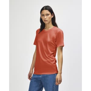 A model wears an American Apparel Tri-Blend T-Shirt in a shade of rust, paired with denim jeans.