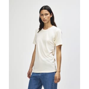 A cream-coloured American Apparel Tri-Blend T-shirt displayed on a model with straight brown hair, paired with blue jeans.