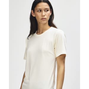 A light cream American Apparel Tri-Blend T-shirt on a model, featuring a relaxed fit and subtle branding.