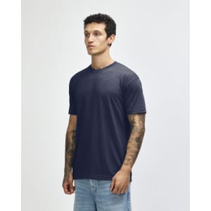 A navy American Apparel tri-blend t-shirt on a model, featuring a simple design and short sleeves.
