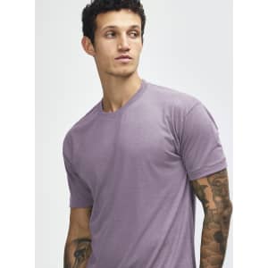 A purple American Apparel tri-blend t-shirt, featuring short sleeves and a round neck. The model has tattoos.