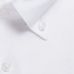 A close-up of a white button-up shirt featuring clear buttons and a classic collar.