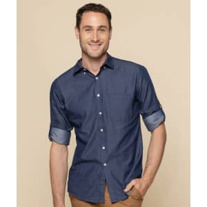A button-up shirt in navy chambray fabric, featuring rolled-up sleeves and a fitted design. It has a logo on it.