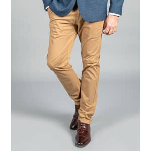 A pair of beige chino pants, featuring a slim fit, worn with a blue blazer and brown dress shoes.