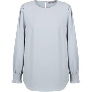 A light blue blouse featuring shirred cuffs and a rounded neckline, with a keyhole back detail.