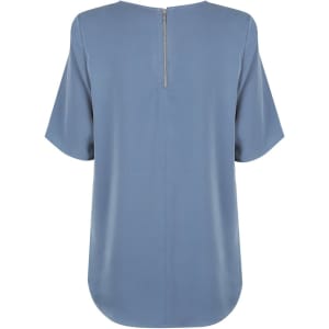 A blue short sleeve shirt with a back zipper, featuring a loose fit and rounded hem. It has a simple design with no visible branding.