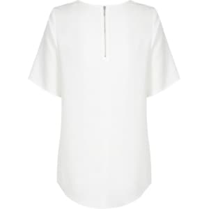 A white short sleeve shirt with a zip at the back and a curved hemline. It has a logo on the label.