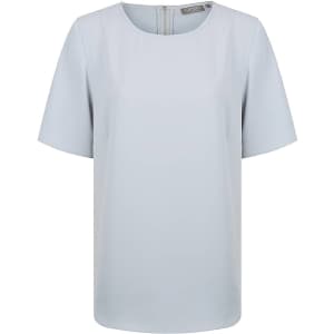 A light blue short sleeve shirt with a round neckline and a zip back. It features a subtle logo on the fabric.