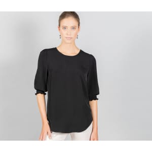 A black top with shirred cuffs, featuring a round neckline and a relaxed fit. The model is styled against a grey background.