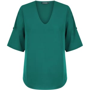 A green v-neck shirt with short sleeves and a rounded hem, featuring a logo on the label.