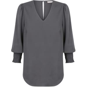 A grey Cleo V Neck shirt featuring a V-shaped neckline and puffed sleeves with smocked cuffs.