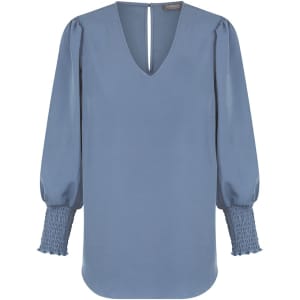A blue Cleo V Neck shirt with a relaxed fit and textured puff sleeves. The back features a small opening and branding.