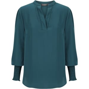 Teal long sleeve top with a V-neckline and gathered sleeve details. Features a branding logo.