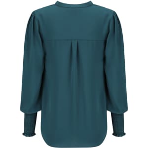 A long sleeve top in deep teal with gathered sleeves and a pleat detail at the back, featuring a branding logo.