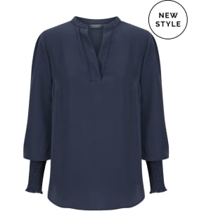 A navy long sleeve top featuring a V-neck and pleated sleeves, with a branding logo present.