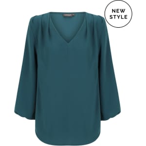 A teal V-neck popover shirt with long sleeves and pleated details. It features a branding logo.