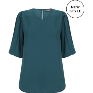 A teal puff sleeve top with a square neckline and a back keyhole detail, featuring a logo.