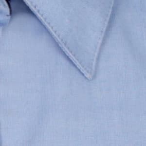 A light blue button-up shirt featuring a classic collar and a minor branding element.