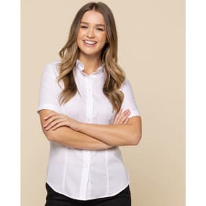 A white button-up shirt featuring short sleeves, worn by a smiling model with long hair.
