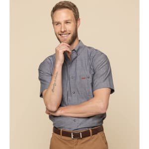 A short-sleeved grey work shirt with a collar and a logo, worn by a smiling man with light hair.