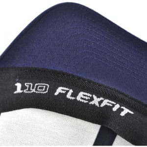 A close-up of a navy and grey trucker cap featuring a logo and the name "FLEXFIT 110" on the inner band.