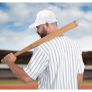 A man in a striped white baseball jersey and white cap holds a wooden baseball bat over his shoulder.