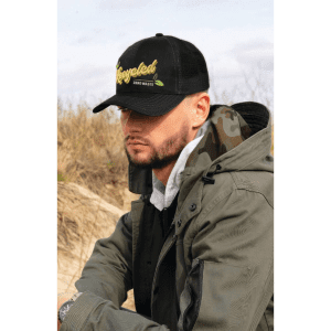 A cap in black with a mesh back, featuring a logo, worn by a person in an outdoor setting.