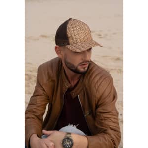A stylish cap featuring a cane print design with a mesh back, worn by a man in a brown leather jacket.