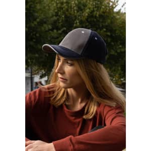 A two-tone cap in grey with contrasting navy stitching, featuring an open lip sandwich design and a logo.