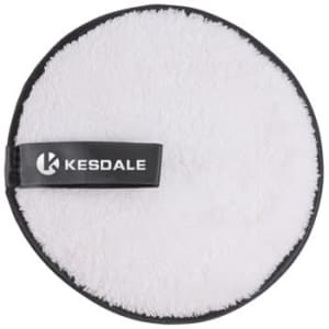 A round, fluffy white reusable makeup remover pad with a black edge and a logo.