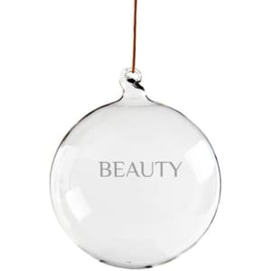 A clear, round glass pendant decoration ball with a brown string for hanging, displaying the word "BEAUTY."