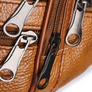 A brown leather fanny bag featuring multiple zippers in silver and black. The textured surface adds a stylish element.