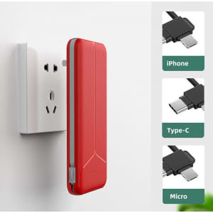 A red power bank with a built-in plug, designed for charging, attached to a wall socket. It features a logo.