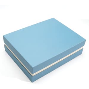 A light blue gift box with a cream-coloured ribbon around it, suitable for holding a notebook and cup set.